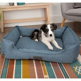 Lifestyle image of dog in pet bed in living room setting