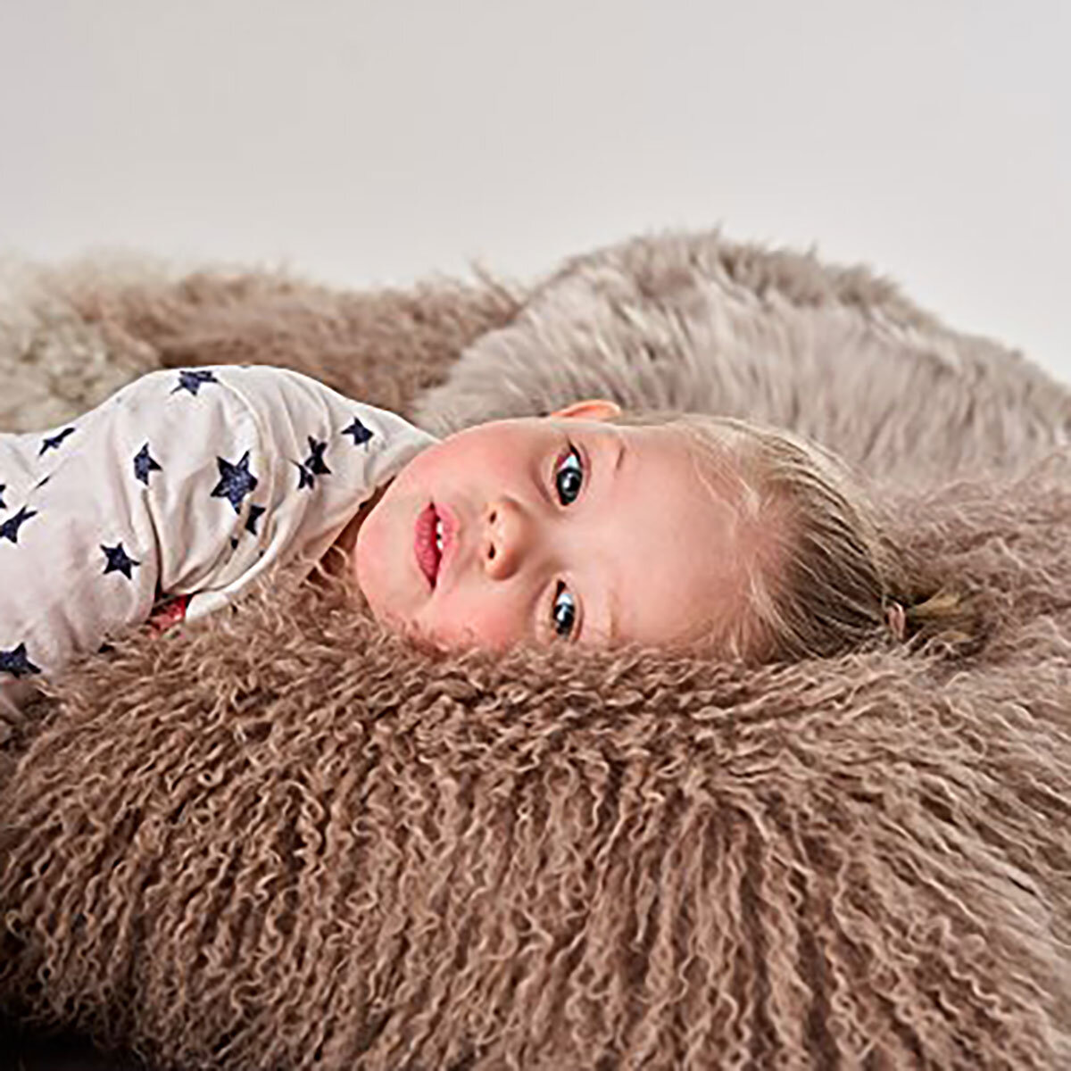 Naturally Sheepskin Mongolian Cushion in mocha with child lying down