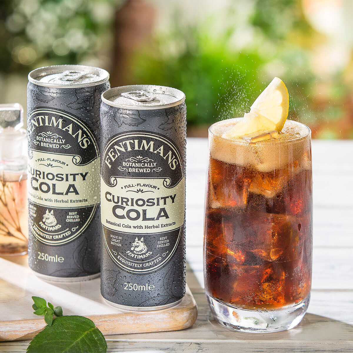 image of 2 cans of fentimans cola in an outdoor setting