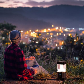 Lifestyle image of someone sat next the lantern overlooking a city Lifestyle image of someone sat next the lantern overlooking a city