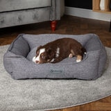 Lifestyle image of dog in pet bed in living room setting