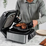 Lifestyle image of Ninja Foodi Grill  with man cooking steaks