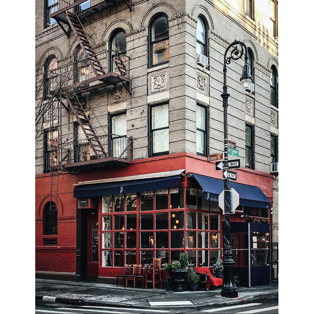 Image of the corner of a grey and red building in New York